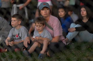 People attend a vigil at Lynnhurst Park to mourn the dead and pray for the wounded after a gunman opened fire on students at Annunciation Catholic School on 27 August 2025 in Minneapolis, Minnesota